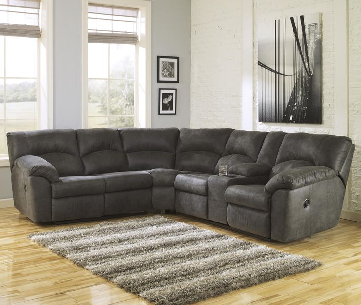 a living room with a sectional couch and two end tables