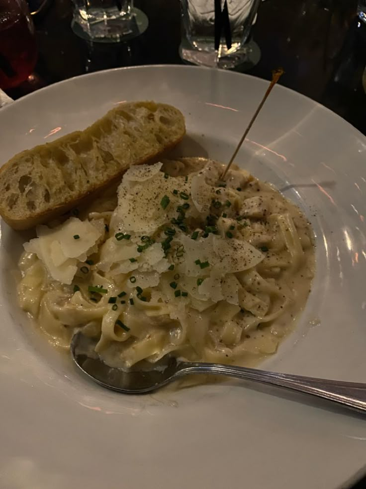 a white plate topped with pasta and bread