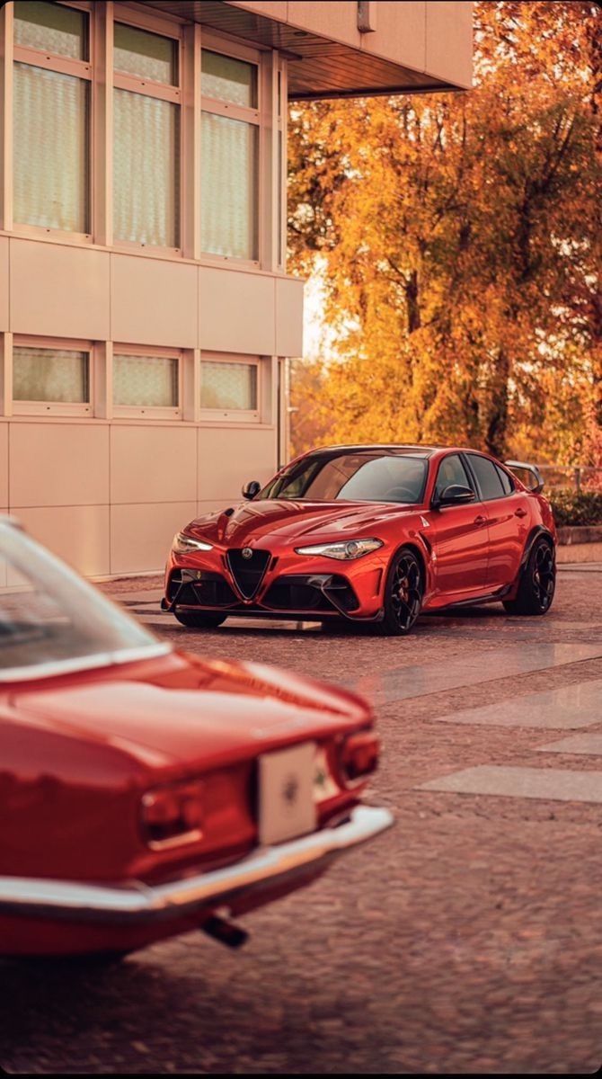 two red cars parked in front of a building