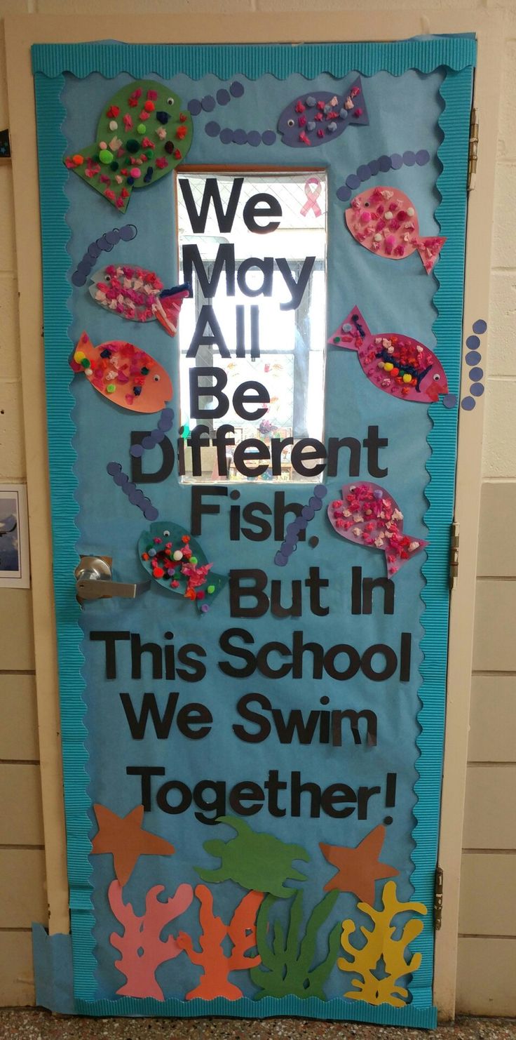 a door decorated with an ocean theme and the words we may all be different fish, but in this school we swim together