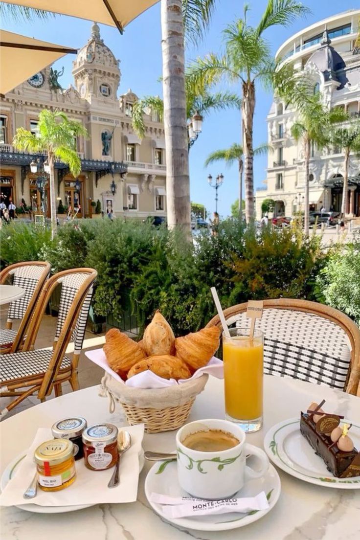 a table topped with plates of food next to a cup of coffee and orange juice