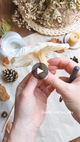 a person holding an object in their hand with other items around it on the table