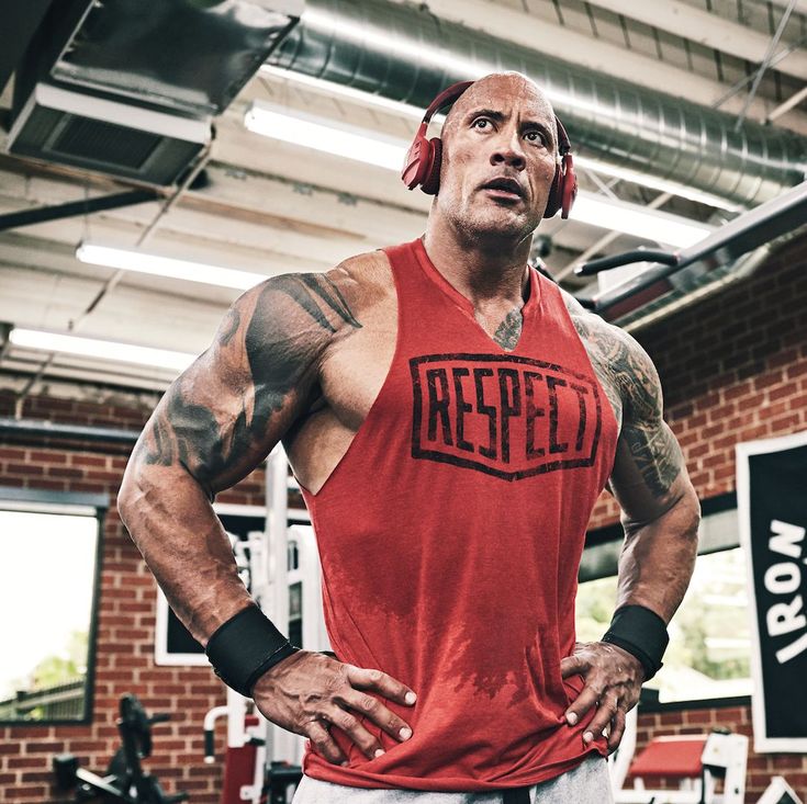 a man with headphones standing in a gym