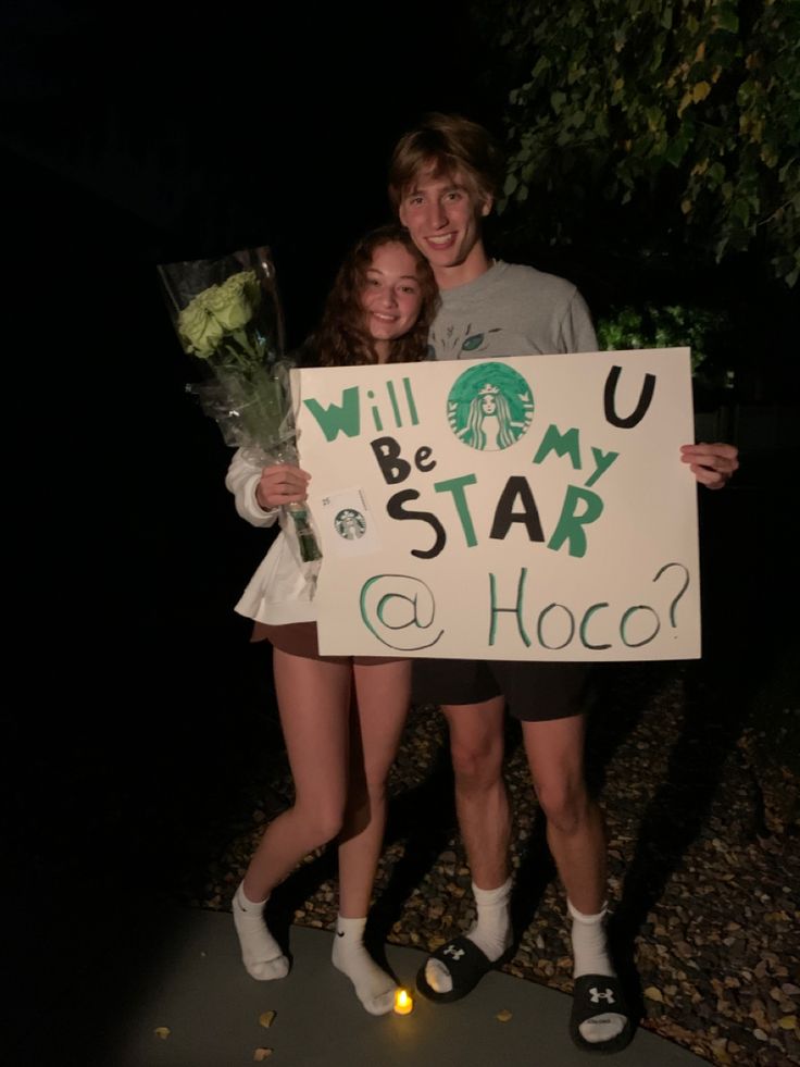 two girls are holding a sign that says will you be my star and hoco?