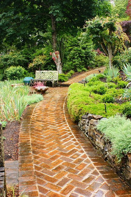 a brick path in the middle of a garden