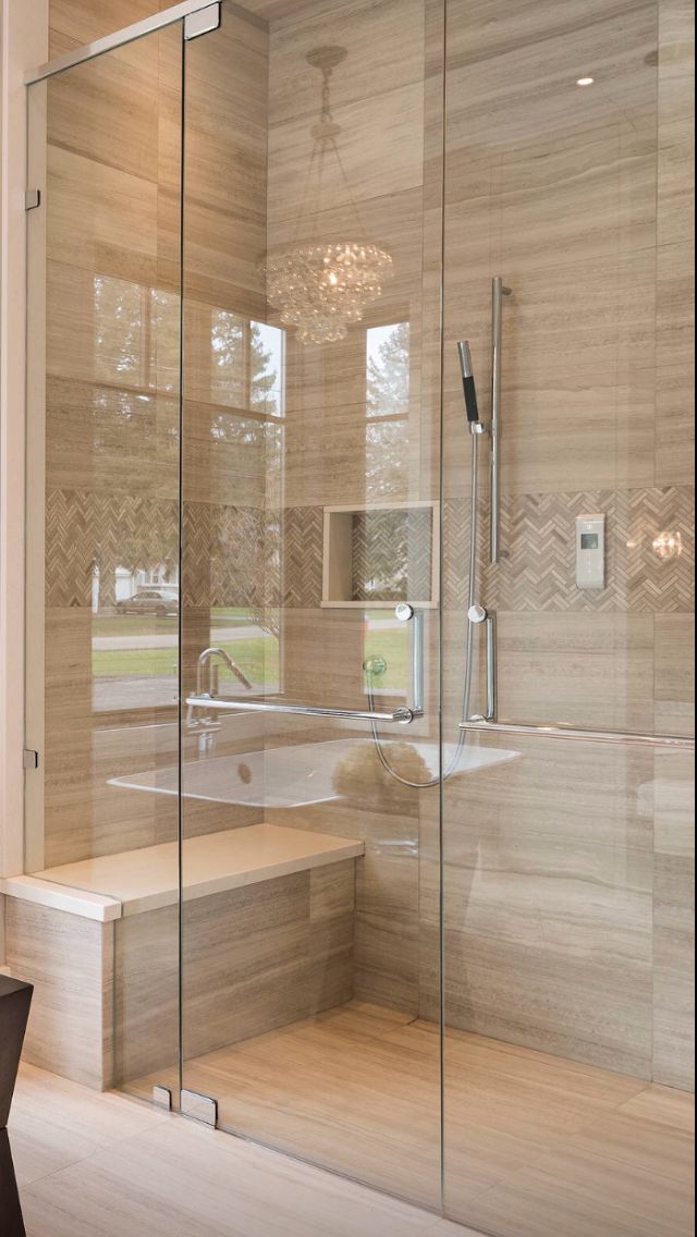 a bathroom with a walk in shower next to a bath tub and wooden flooring