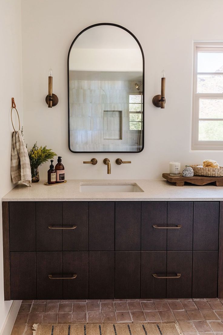 a bathroom vanity with a large mirror above it