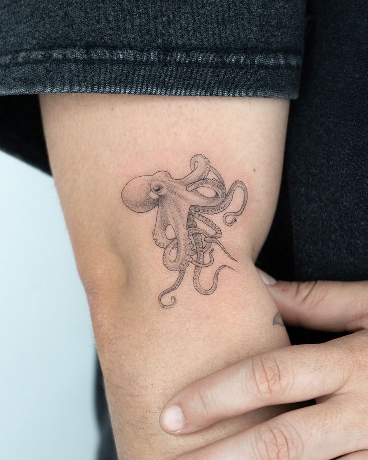 an octopus tattoo on the left side of the arm is shown in black and white