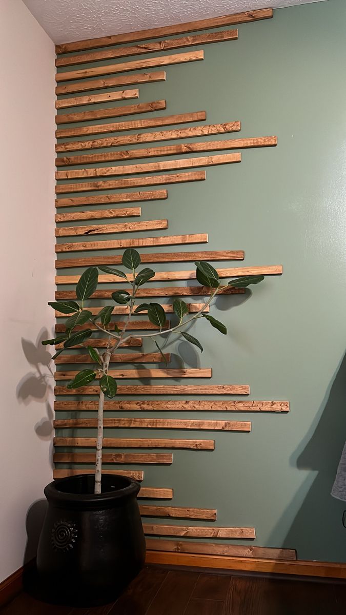 a potted plant sitting on top of a wooden table next to a green wall