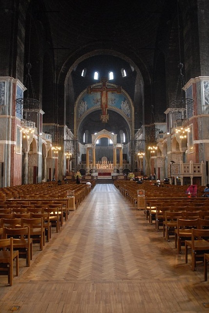 an empty church with wooden pews and chandeliers