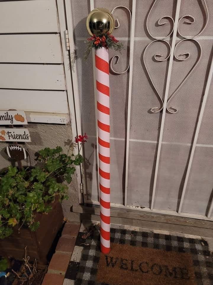 a red and white striped pole is standing in front of a door