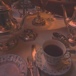 there is a tea set on the table with silverware and cups in front of it