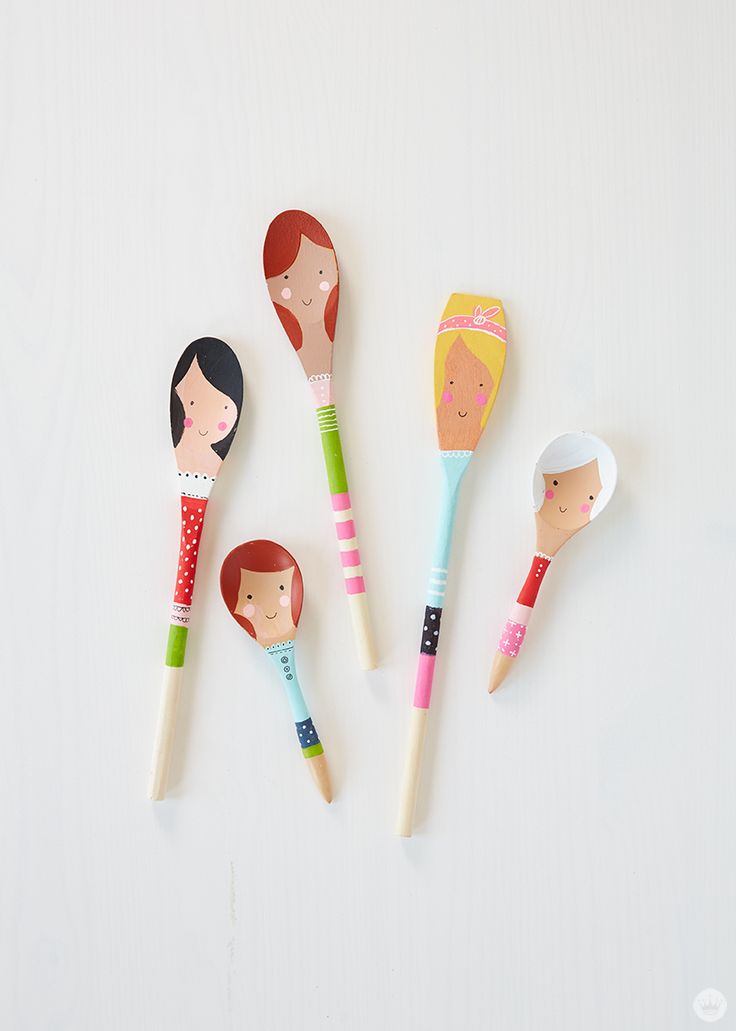 five wooden spoons with different designs on them