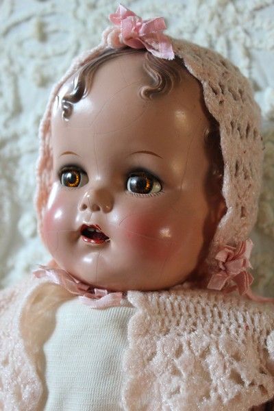 an old fashioned baby doll wearing a pink bonnet