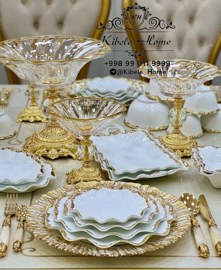 a table topped with lots of white plates and gold trimmings on top of each other