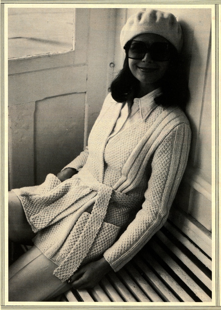 black and white photograph of a woman sitting on a bench wearing a knitted dress