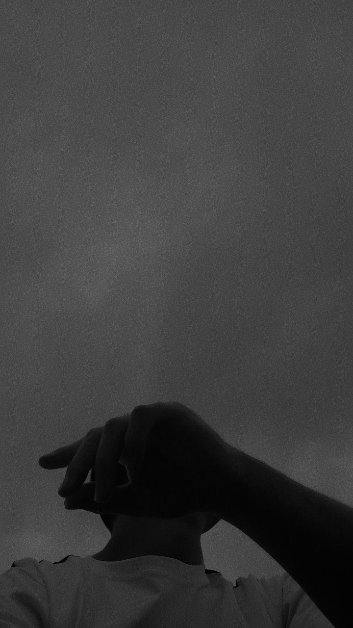 black and white photograph of a person pointing at something in the sky with his hand