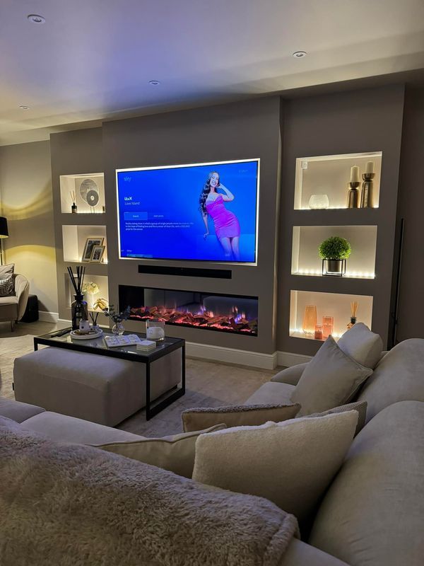 a living room filled with furniture and a flat screen tv mounted on the wall above a fire place