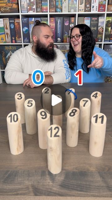 two people sitting at a table with numbers on it and one person pointing to them