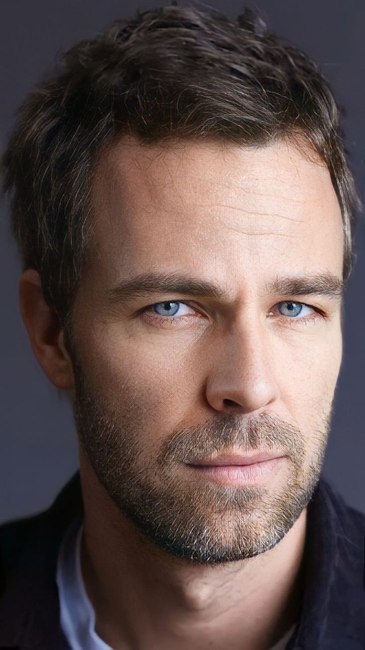 a close up of a person wearing a suit and tie with a blue eyeshade