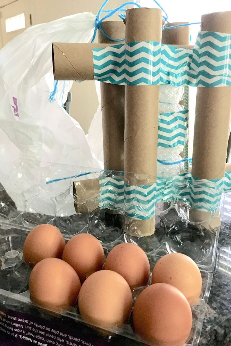 some eggs are sitting in cartons on a table with blue and white paper wrapped around them