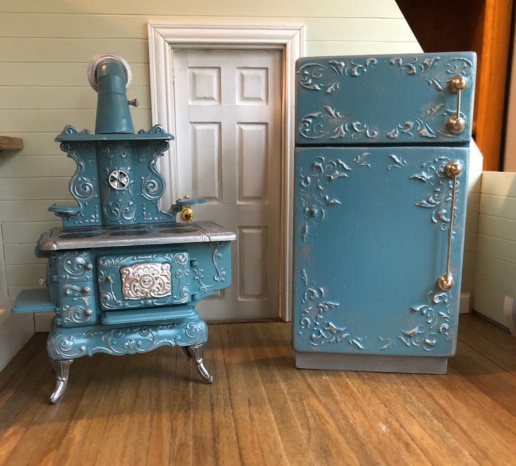 two blue stoves sitting next to each other on top of a wooden floor