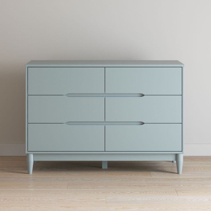 a blue dresser sitting on top of a hard wood floor next to a white wall