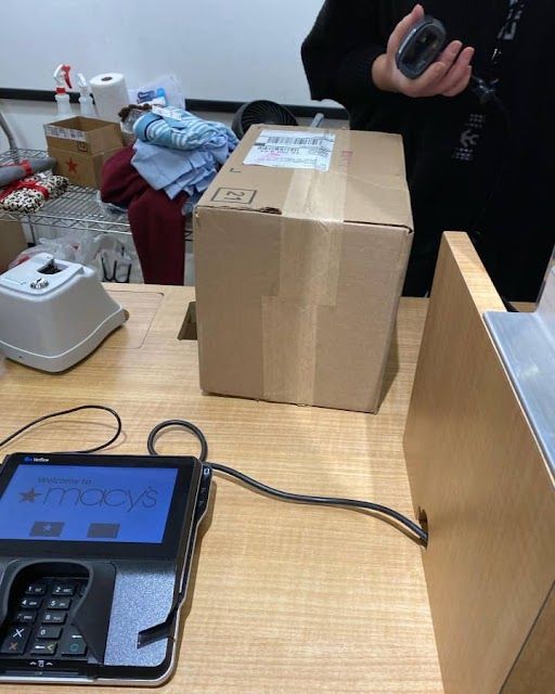 a cell phone sitting on top of a wooden table next to boxes and other items