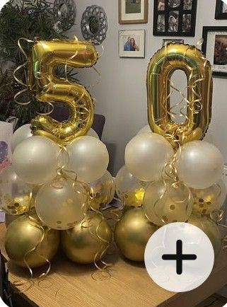 gold and white balloons in the shape of numbers are on a table with other decorations