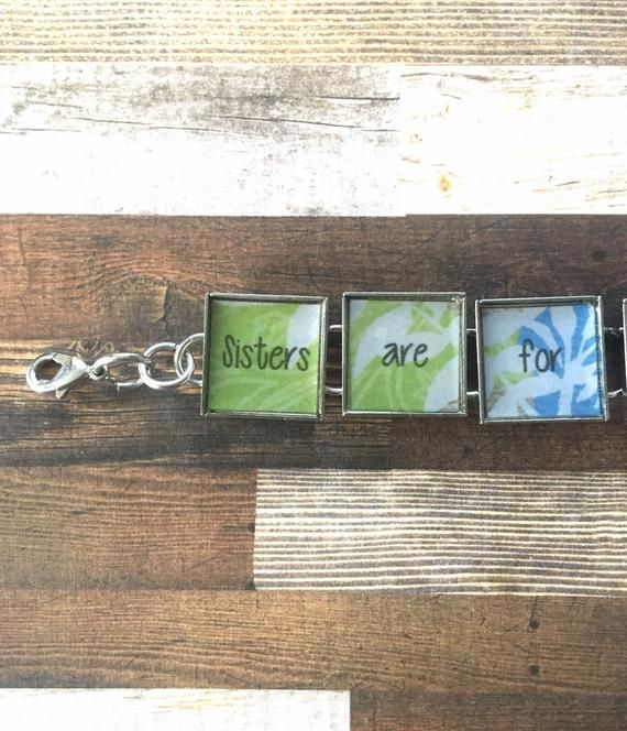 four squares with the words sisters are for you on them hanging from a key chain