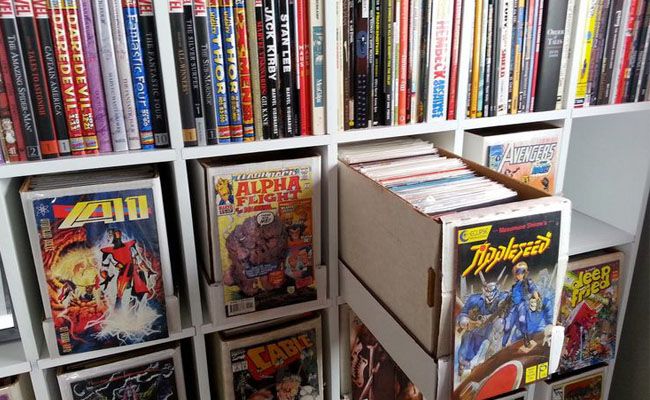 a bookshelf filled with comic books and comics on top of each bookcase