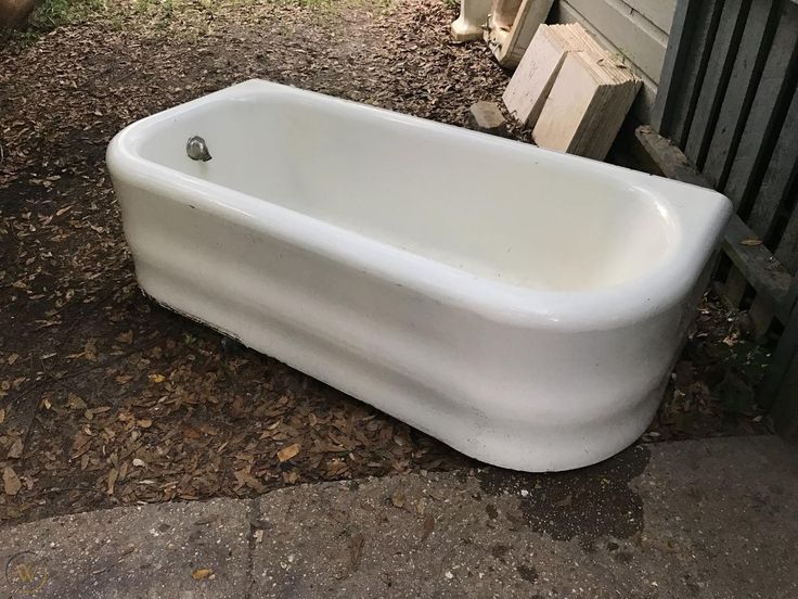 a white bath tub sitting on the ground