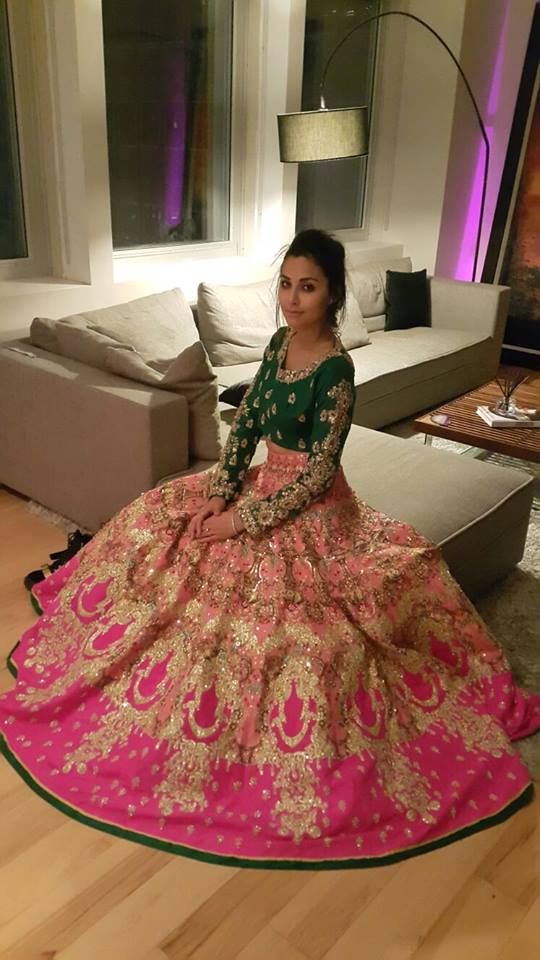 a woman is sitting on the floor in a pink and green dress with gold details