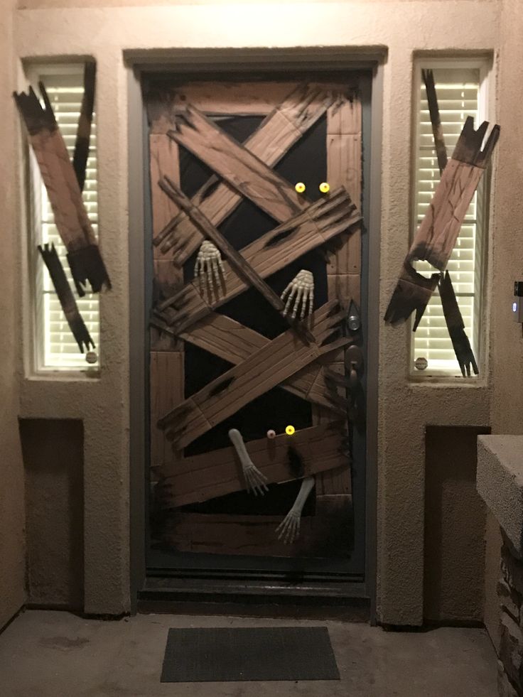 a door decorated with skeleton hands and yellow eyes