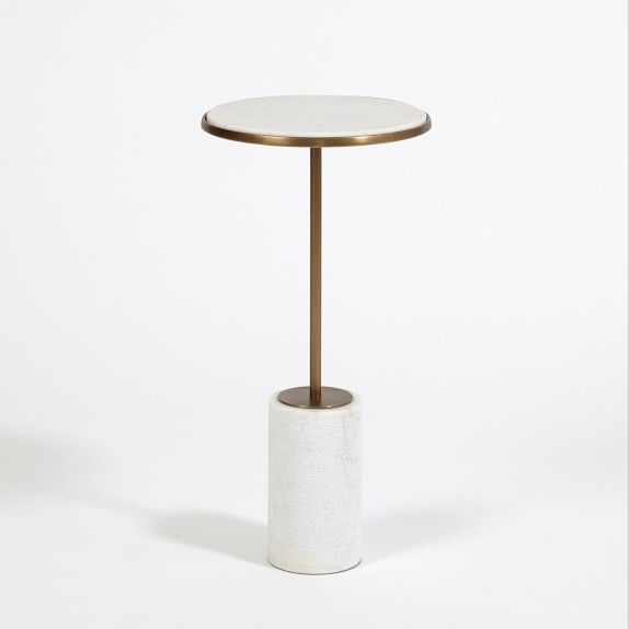 a white table with a gold metal base and a round marble top on a white background