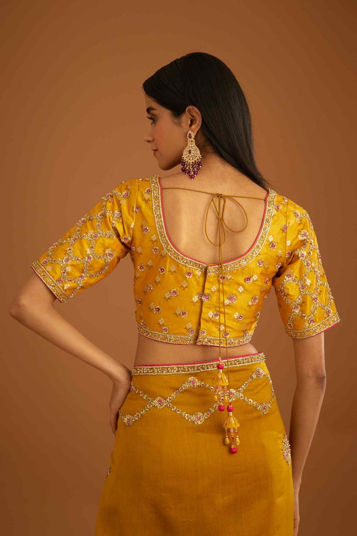 Editor's Note A mustard yellow zardozi embroidered dupion silk sari and blouse would be a stunning choice for a traditional event or wedding. The rich and vibrant color paired with intricate zardozi embroidery would make for a gorgeous and elegant ensemble. Color: Mustard yellow Fabric: Dupion silk & chanderi Embroidery details: Zardozi embroidery Components: Sari & blouse Sari length: 6 meters, sari width: 46" inches Occasion: Festive and Wedding Guest Disclaimer: Product color may slightly var Fitted Yellow Pre-draped Saree With Pallu, Festive Yellow Raw Silk Pre-draped Saree, Gold Pre-draped Saree For Reception, Transitional Gold Sharara With Dori Work, Festive Yellow Fitted Pre-draped Saree, Yellow Dola Silk Pre-draped Saree For Navratri, Transitional Yellow Sharara With Zari Work, Ceremonial Pre-draped Saree With Cutdana For Transitional Season, Transitional Designer Yellow Pre-draped Saree