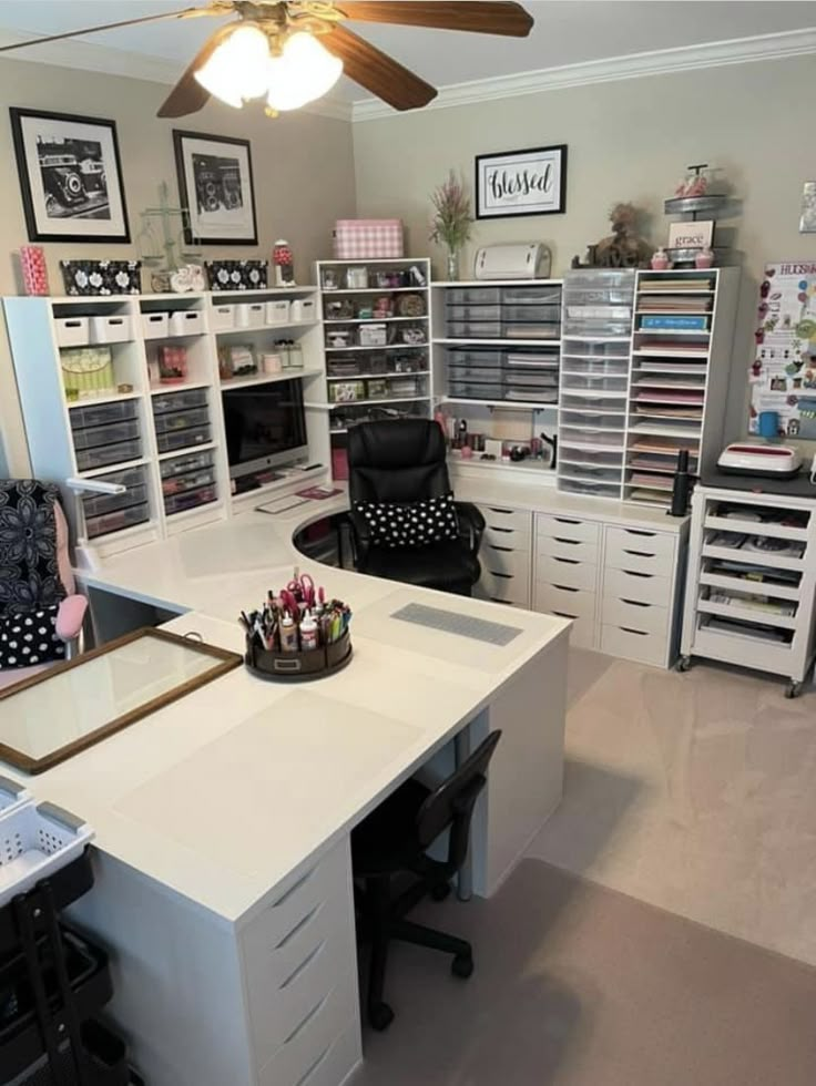 a white desk topped with lots of drawers under a ceiling fan