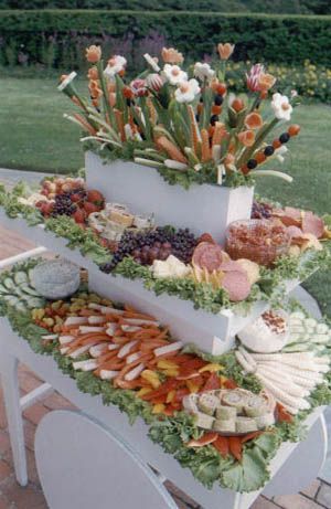 two tiered trays filled with assorted fruits and veggies on a table