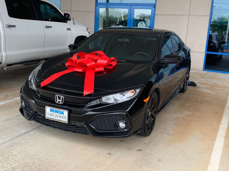 a black car with a red bow on it