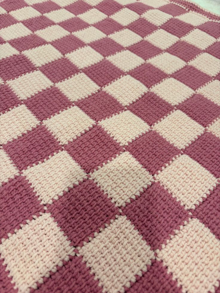 a crocheted blanket is laying on the floor