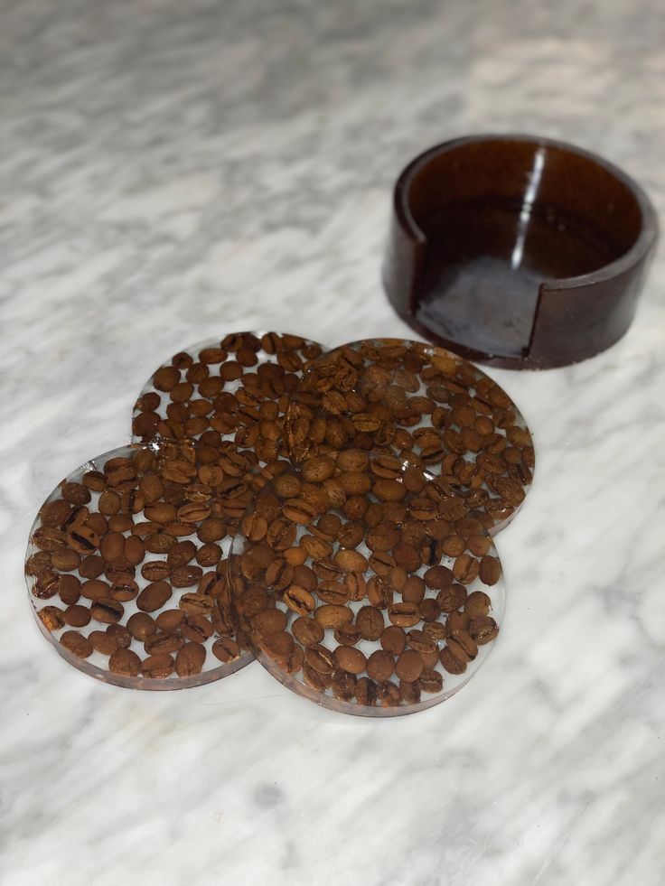 two coasters made out of coffee beans on a marble surface