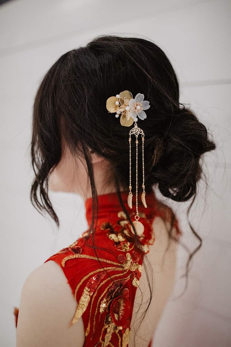 the back of a woman's head wearing a red dress with flowers on it