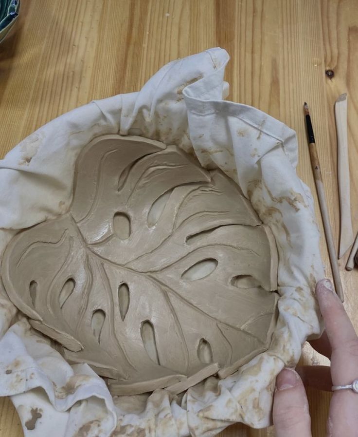 a person is making a bowl out of clay