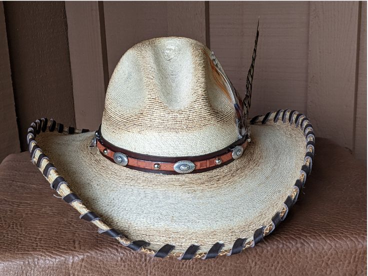 A hat for all occasions! The hat body is a very soft hat and has been flame distressed. The brim is 4" and has a wire in it to shape it further. The crown is 5". This hat has stampede strings so it stays on in those high winds. Hand laced in brown leather The layered hat band is brown leather with Southwestern imprinted whiskey brown leather and accented with sunburst sliders and nailspots. The back of the band has a deer antler bead. Finished with a long Ringneck Pheasant feather and smaller ph Rustic Adjustable Brimmed Top Hat, Rustic Hats For Rodeo, Rustic Flat Brim Hat For Rodeo, Rustic Adjustable Hat With Curved Brim, Rustic Top Hat With Adjustable Flat Brim, Rustic Top Hat With Flat Brim For Country Events, Rustic Rodeo Hat, Rustic Adjustable Brimmed Hat, Southern Style Fedora For Western-themed Events