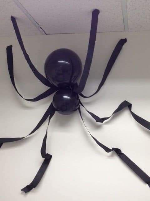 a large black spider sitting on top of a white table