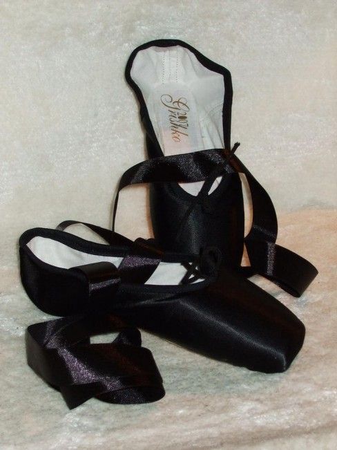 a pair of black ballet shoes sitting next to each other