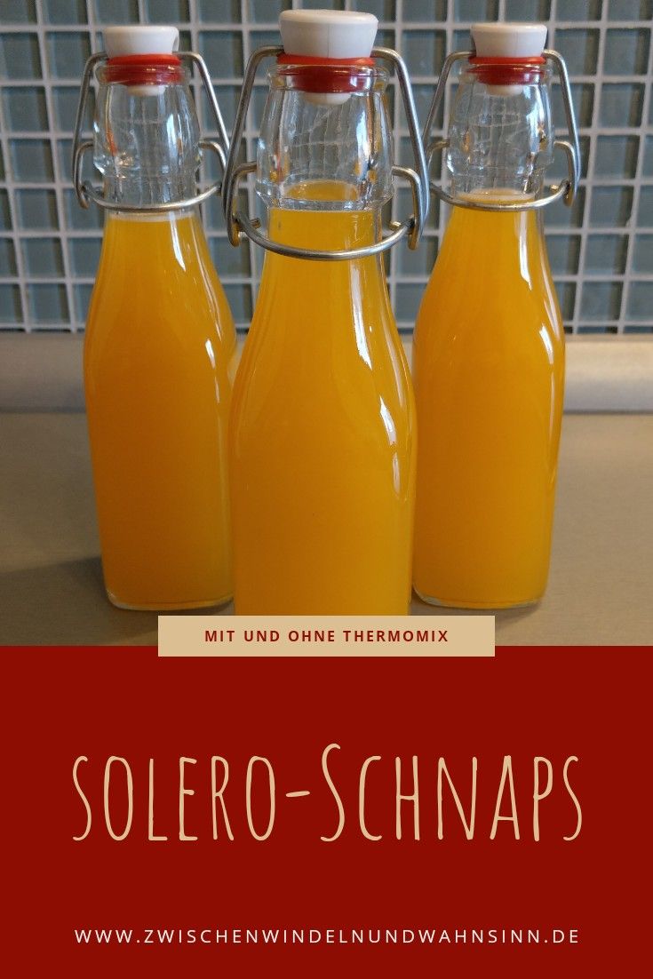 three bottles filled with orange juice sitting on top of a counter