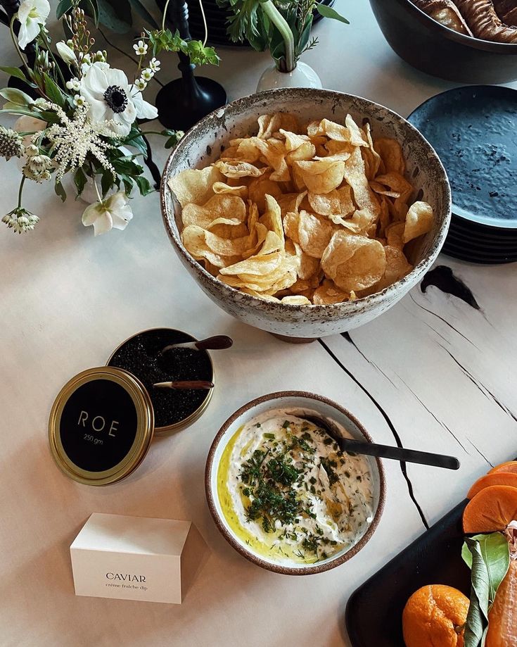 chips and dips on a table with flowers