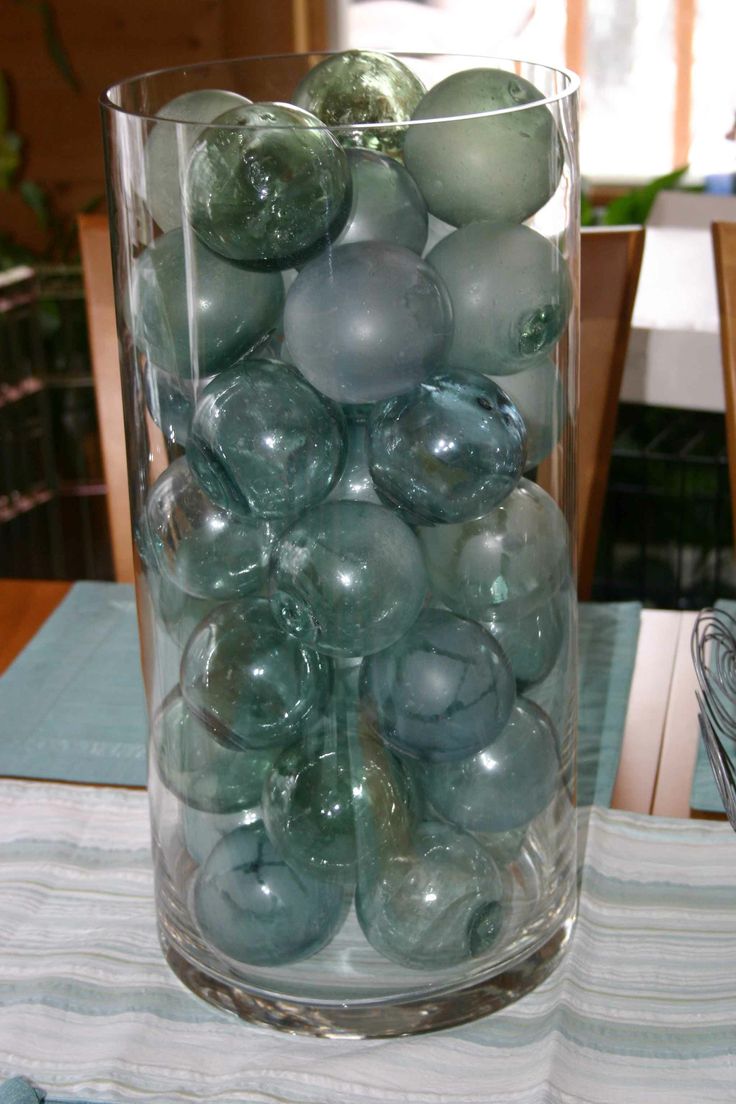 a vase filled with glass balls on top of a table