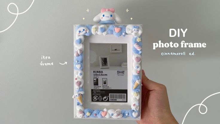 a hand holding up a photo frame that is decorated with pastel blue and white flowers